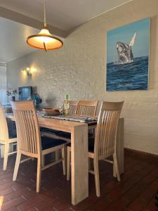 斯科特堡Dolphin View Self Catering的一间带木桌和椅子的用餐室