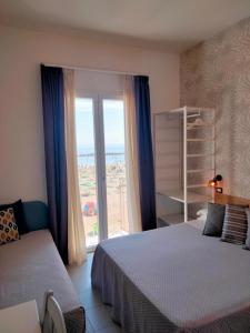 里米尼拉奎拉酒店的一间卧室设有两张床和大窗户