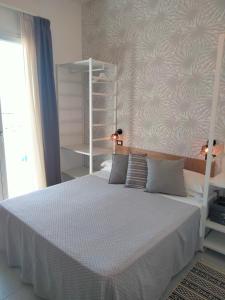 里米尼拉奎拉酒店的卧室配有白色的床和墙壁