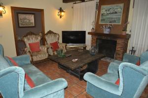 加拉帕加尔LA CASA DE GALAPAGAR ALOJAMIENTO SIETE PICOS的客厅配有蓝色椅子和壁炉