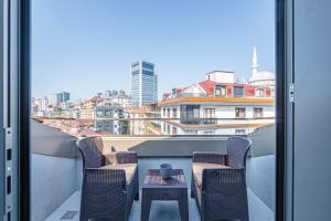 伊斯坦布尔Homie Suites - Newly-constructed Apartment Complex in Beşiktaş的阳台配有2把椅子和1张桌子,享有风景。