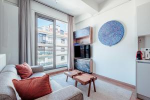 伊斯坦布尔Homie Suites - Newly-constructed Apartment Complex in Beşiktaş的带沙发和大窗户的客厅