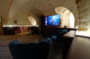 蒙斯Secret Jacuzzi Mons - Parking privé gratuit的洞穴内的房间,配有椅子和电视