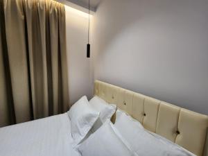 伏罗拉Sea Front Villa的一间卧室配有带白色床单和枕头的床。