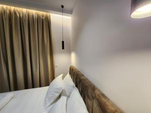 伏罗拉Sea Front Villa的一间卧室配有一张带白色床单的床和一扇窗户。