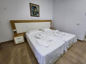 伏罗拉Sea Front Villa的卧室配有白色床和毛巾