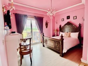 五结英格兰小古堡的粉红色的卧室配有床和椅子