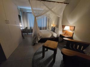 马普托Sundown Guest House Maputo的一间卧室配有一张带天蓬的床