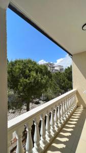 维利波吉Kamberi Hotel & Apartments的阳台设有白色栏杆,享有海滩美景。