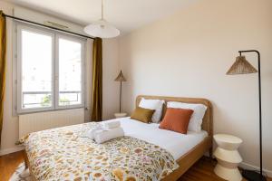 维勒班DIFY Republique - Villeurbanne的卧室配有带枕头的床铺和窗户。