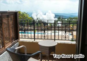 雾岛市La Vista Kirishima Hills的设有一个配有桌椅并享有美景的阳台。