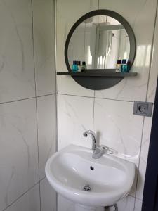 MackaAyas Apart的浴室设有白色水槽和镜子