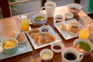 圣地亚哥Verde Madera Hostel B&B的一张木桌,上面放着早餐食品和饮料