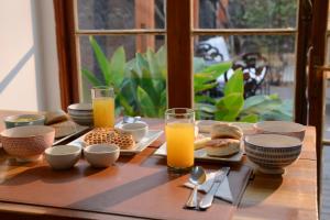圣地亚哥Verde Madera Hostel B&B的一张带早餐食品和橙汁的木桌