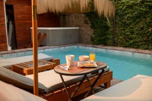圣地亚哥Verde Madera Hostel B&B的一张桌子,旁边是游泳池,上面有盘子