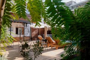 圣地亚哥Verde Madera Hostel B&B的庭院配有椅子和遮阳伞,并种植了植物