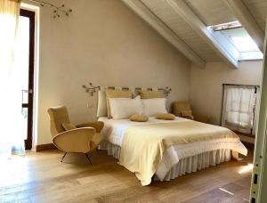 伊斯普拉Tenuta La Quassa的一间卧室配有一张大床和两把椅子