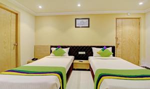 加尔各答Treebo Trend ASL Prime的一间酒店客房,房间内设有两张床