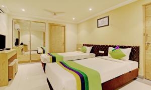 加尔各答Treebo Trend ASL Prime的酒店客房设有两张床和电视。