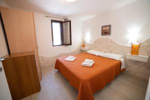 维耶斯泰艾萨波里德尔加尔加诺酒店的一间卧室配有一张床,上面有两条毛巾