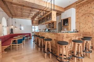 阿罗萨Hotel Alpensonne - Panoramazimmer & Restaurant的餐厅内的酒吧,设有木墙和凳子