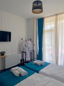 卡兹贝吉Mood Hotel Kazbegi的一间卧室配有两张带毛巾的床