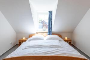 布雷茨特Haus zu den Halligen的一间卧室设有两张床和窗户。