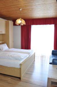 滨湖波德斯多夫Gästehaus Herlinde的一间卧室配有床和红色窗帘