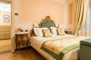 佛罗伦萨伯尼尼宫酒店的一间卧室配有一张带绿色床头板的床