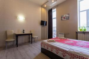 哈尔科夫马龙公寓的一间卧室配有一张床、一张桌子和一个窗户。