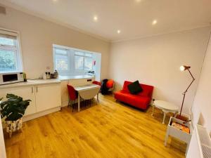 滨海绍森德NEW modernised flat in the heart of Leigh on Sea的客厅配有红色沙发和红色椅子