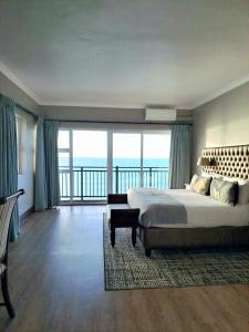 莫塞尔湾Diaz Hotel and Resort的一间带大床的卧室和一个阳台