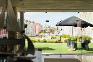 普拉亚达维埃拉Hotel Cristal Praia Resort & SPA的从带雨伞的餐厅欣赏到公园的景色