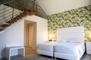 普拉亚达维埃拉Hotel Cristal Praia Resort & SPA的卧室配有白色的床和楼梯。