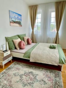 凯斯特海伊Libás Apartman的一间卧室配有一张带两个绿色和粉红色枕头的床
