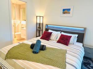 墨尔本Sweet Home Apartment North Melbourne的一张带红色枕头和绿色地毯的大床