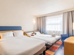 达迪利B&B HOTEL Lyon Nord 4 étoiles的酒店客房设有两张床和窗户。