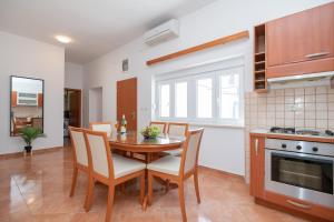 伊莫茨基Apartment Petra的厨房以及带桌椅的用餐室。