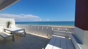 利尼亚诺萨比亚多罗Residence Luna的阳台配有桌子,享有海滩美景