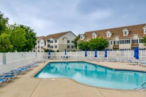 杜威海滩Condo with Pool Access about 2 Mi to Rehoboth Beach!的一个带椅子和围栏的游泳池