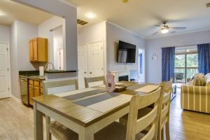 杜威海滩Condo with Pool Access about 2 Mi to Rehoboth Beach!的厨房、带木桌的客厅和用餐室