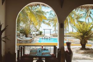 普瓦尼梅查恩加尼Mambo Ocean Resort的度假村拱门享有游泳池的景致