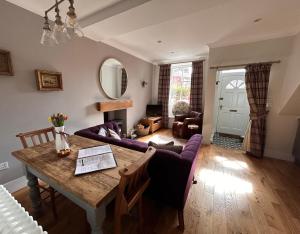 邓布兰The Cottage的客厅配有桌子和紫色沙发