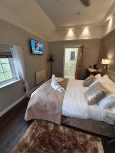 泰克利Old Thatch Bambers Green的一间卧室设有一张大床和一台墙上的电视。