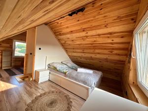 什奇特诺Domki na Mazurach - Marksewo的小屋内的卧室,设有木墙