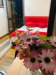 格拉玛多Residenciais Maria Flor的卧室里一张桌子上装有粉红色花的花瓶