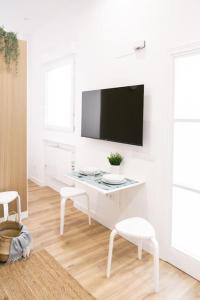 马德里Acogedor y conveniente piso reformado en Salamanca的白色的客厅配有白色的办公桌和电视。