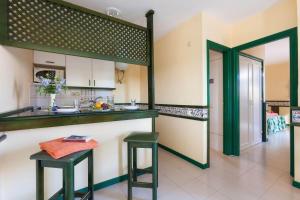 卡勒达德福斯特波多黎各卡莱塔酒店的厨房配有2张绿色凳子和1个柜台