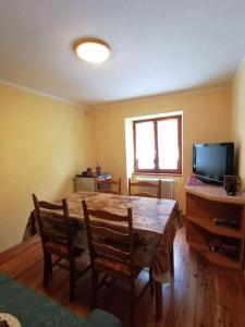 坎波多尔奇诺Appartamento sul Liro的配有桌椅和电视的客房