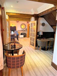 水上伯顿Cotswold Merrymouth Inn的客厅铺有木地板,配有桌椅。